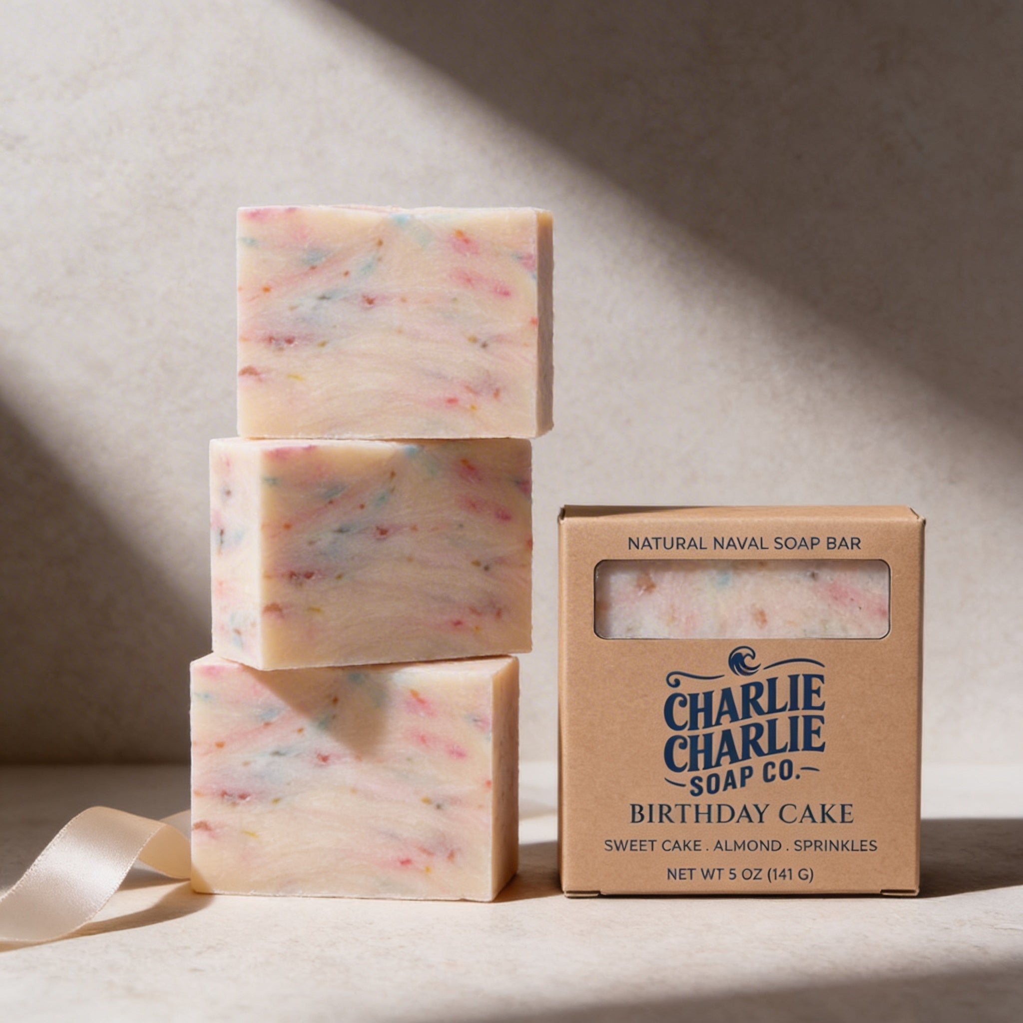 Three bars of 'Birthday Cake' soap by Charlie Charlie Soap Co. on a neutral background