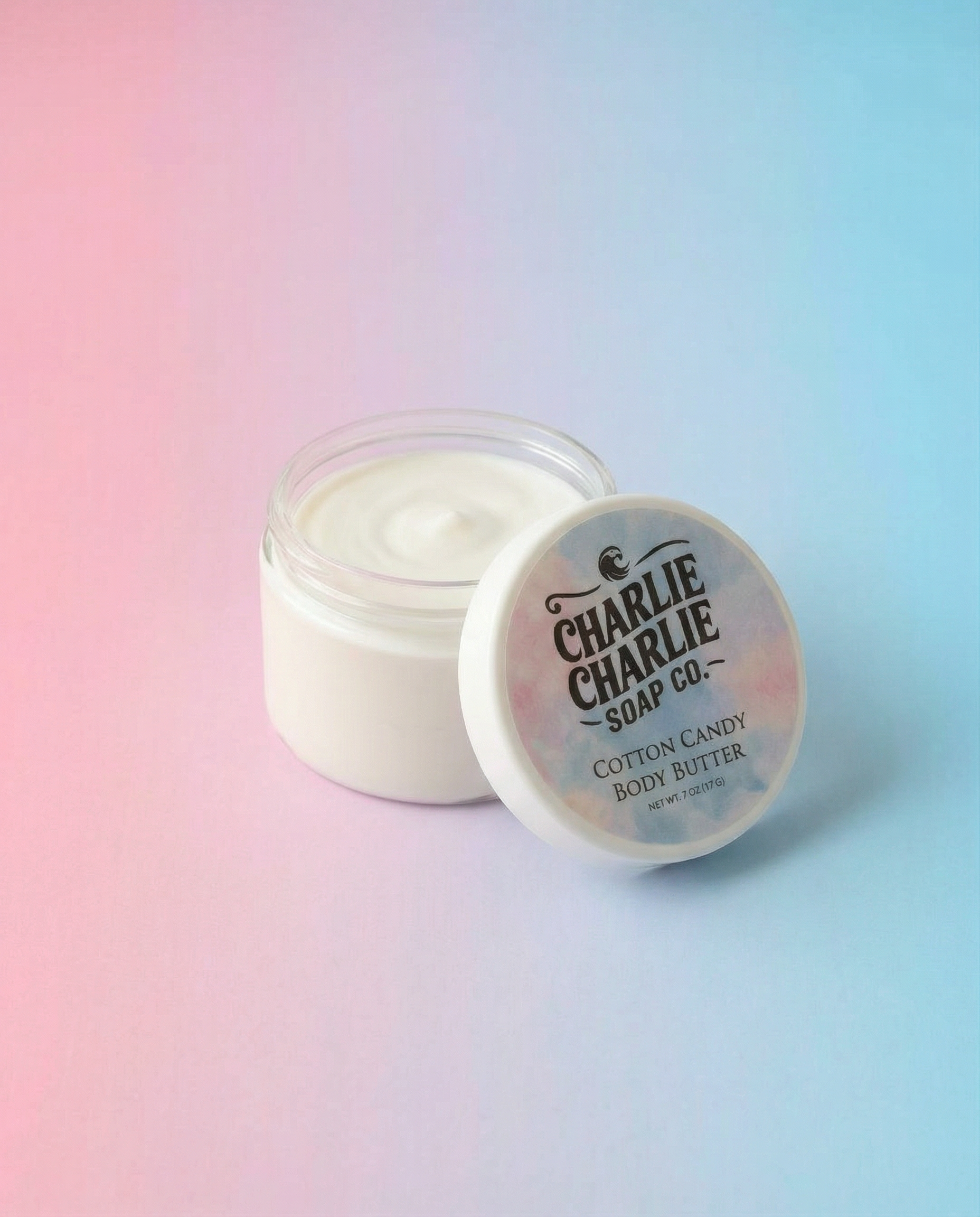 Jar of cotton candy body butter with 'Charlie Charlie Soap Co.' label on a gradient background