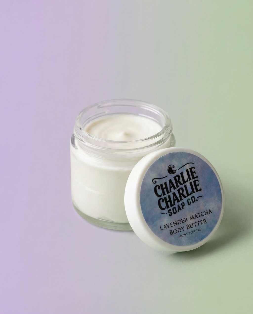 Jar of Charlie Charlie Soap Co. lavender matcha body butter on a gradient background