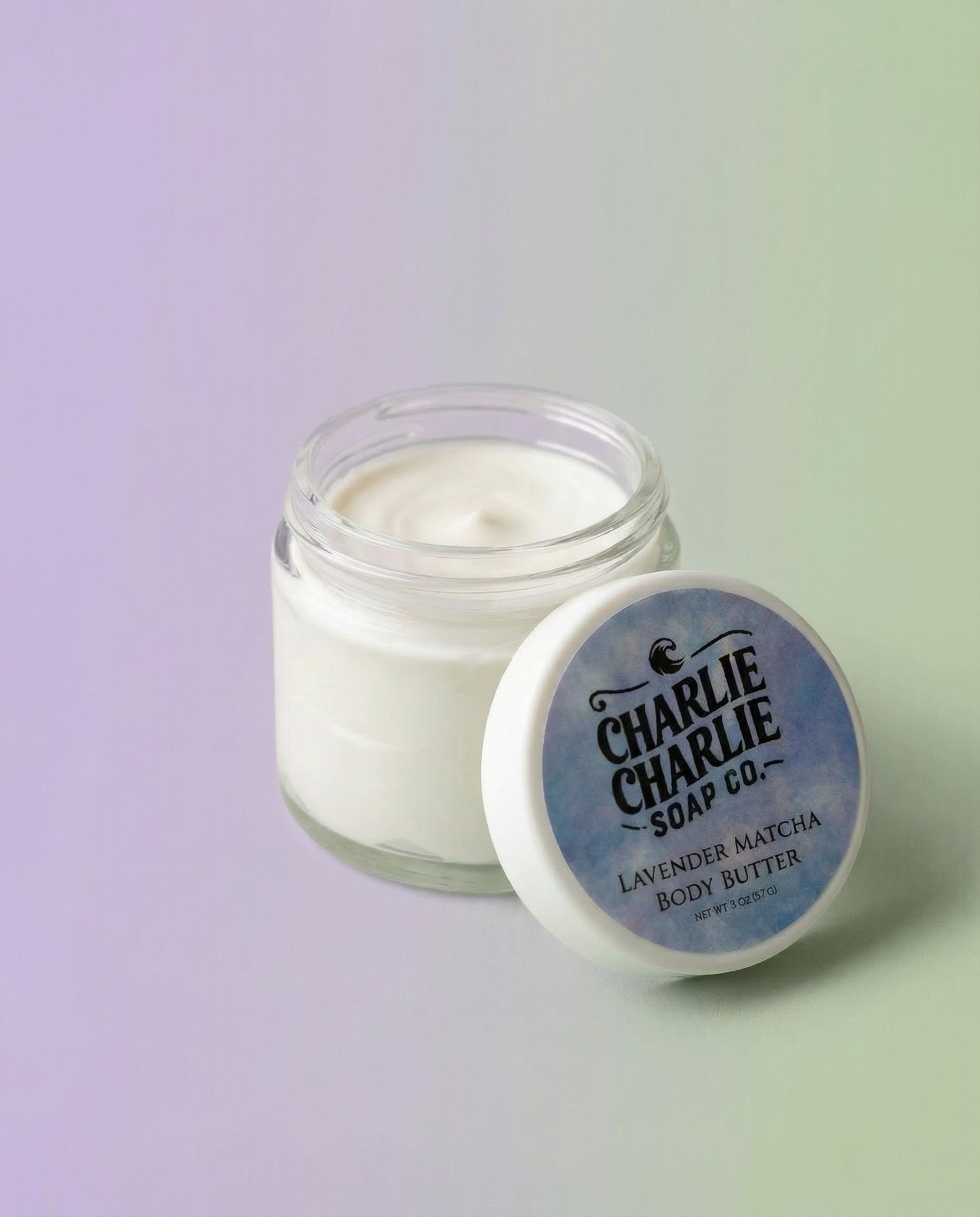 Jar of Charlie Charlie Soap Co. lavender matcha body butter on a gradient background