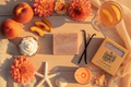 Table setting with peaches, flowers, soap, and a glass of iced tea on a wooden surface.