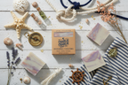 Bar of soap with packaging on a wooden surface with decorative items