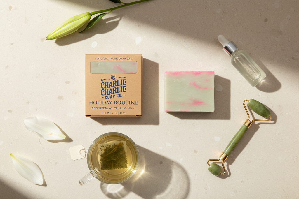 Assorted beauty and wellness products including a tea bag, soap bar, roller, and bottle on a light surface.