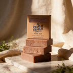 Three bars of soap stacked on a marble surface with 'Charlie Charlie Soap Co.' packaging.