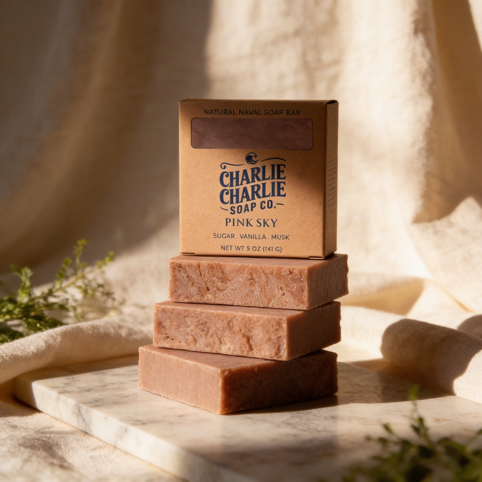 Three bars of soap stacked on a marble surface with 'Charlie Charlie Soap Co.' packaging.