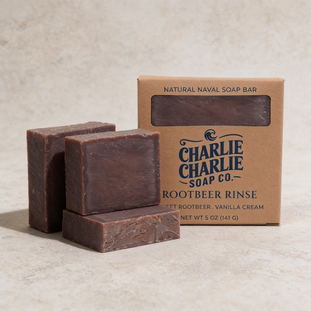 Three bars of Charlie Charlie Soap Co. soap with a packaging box on a beige background