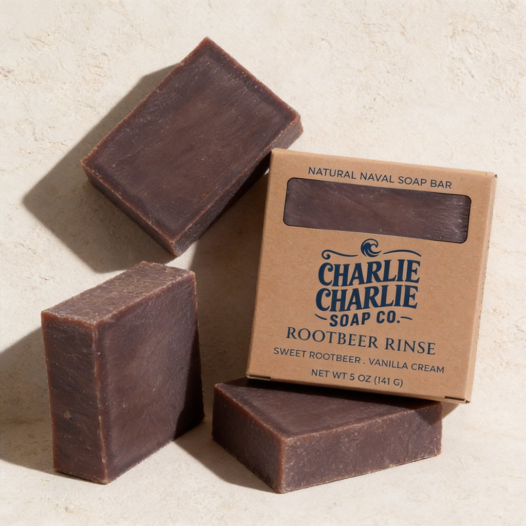 Three bars of soap and their packaging from Charlie Charlie Soap Co. on a light background