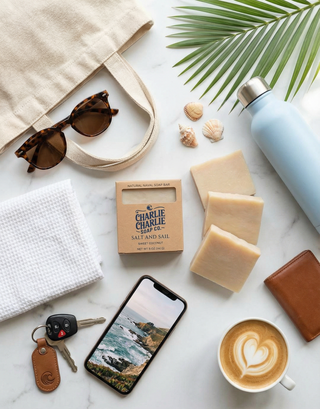 Collection of items including a phone, coffee, soap, and a bag on a marble surface.
