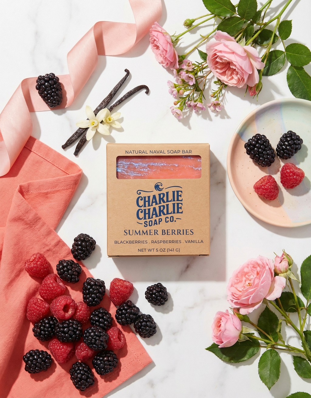 Charlie Charlie Soap Co. bar of soap with summer berries flavor surrounded by blackberries, raspberries, and vanilla beans on a marble surface.
