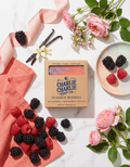 Charlie Charlie Soap Co. bar of soap with summer berries flavor surrounded by blackberries, raspberries, and vanilla beans on a marble surface.